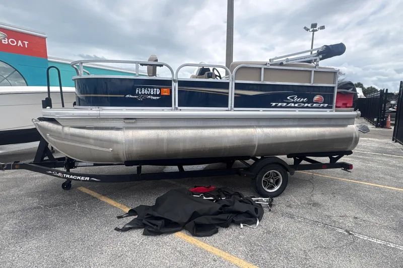 Slide: The Image of 2022 Sun Tracker Bass Buggy 16 XL Select pontoon boat on trailer in parking lot. - 3