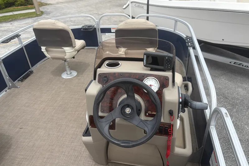 Slide: The Image of 2022 Sun Tracker Bass Buggy 16 XL Select pontoon boat interior with steering console and seating. - 7