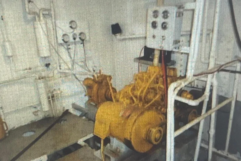 Slide: The Image of Engine room of a 1984 Commercial Freezer Shrimp Trawler with yellow machinery and control panels. - 4
