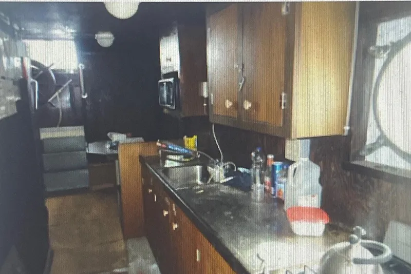 Slide: The Image of Interior of a 1984 commercial freezer shrimp trawler kitchen with wooden cabinets and countertop. - 6