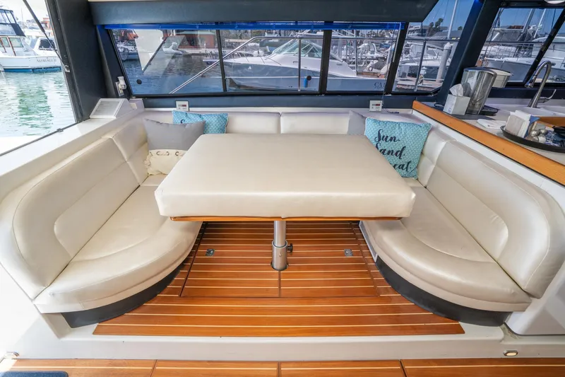 Slide: The Image of Interior of 1992 Bayliner 4388 yacht with cushioned seating and wooden flooring. - 26