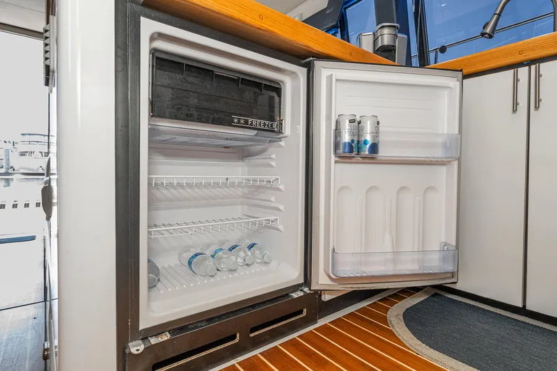 Slide: The Image of Open fridge on 1992 Bayliner 4388 yacht, stocked with water bottles and canned drinks. - 34