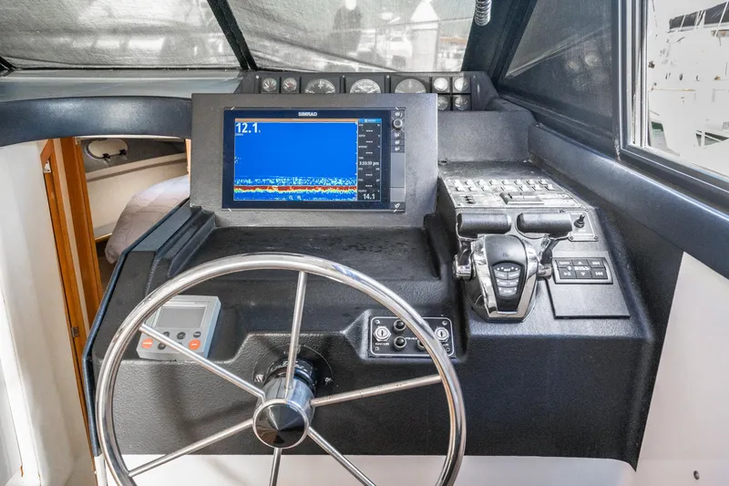 Slide: The Image of 1992 Bayliner 4388 helm with steering wheel, navigation display, and control panel. - 38
