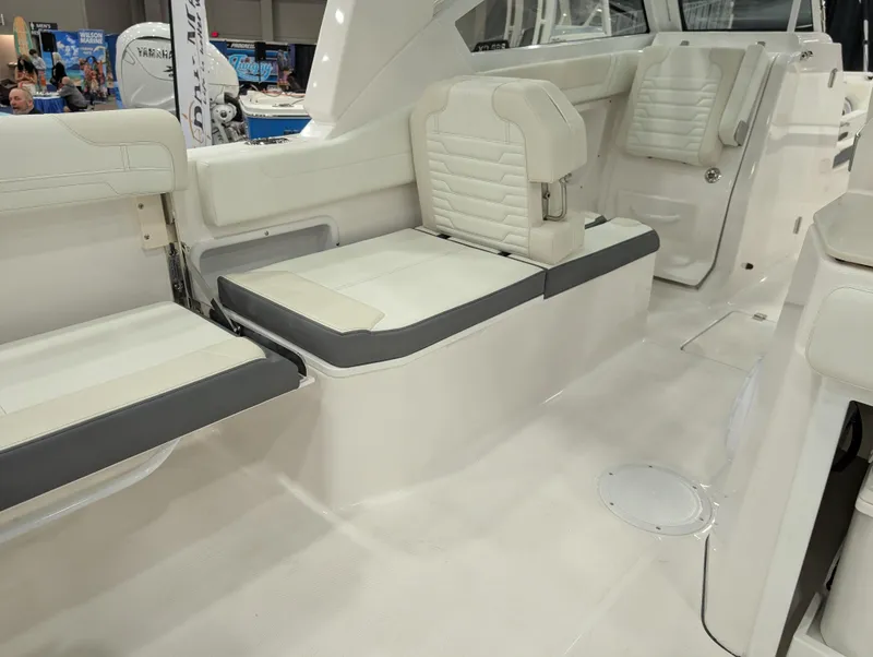 Slide: The Image of 2025 Edgewater 262 CX boat interior with white cushioned seating and modern design. - 10