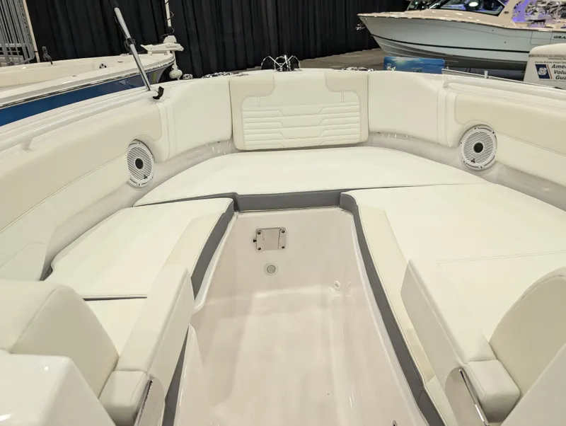Slide: The Image of 2025 Edgewater 262 CX boat interior with white seating and speakers. - 11
