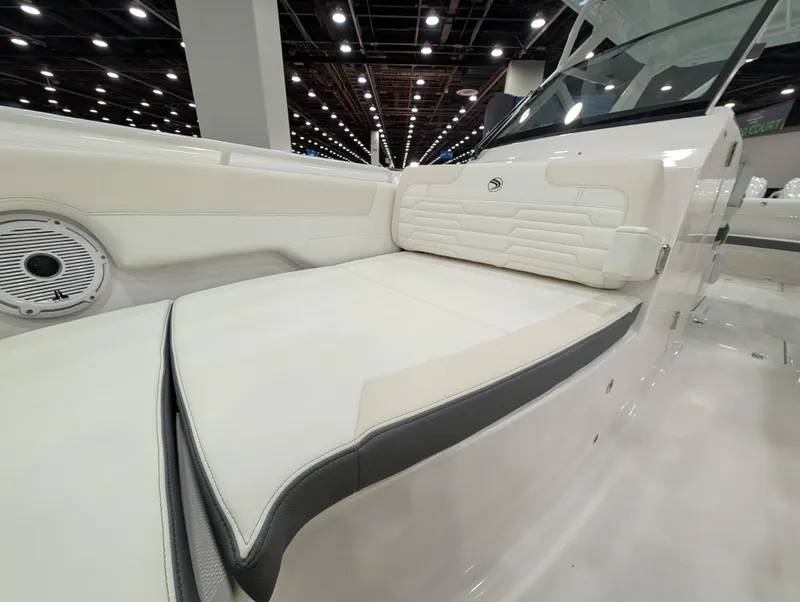 Slide: The Image of 2025 Edgewater 262 CX boat interior with white cushioned seating and speaker. - 44