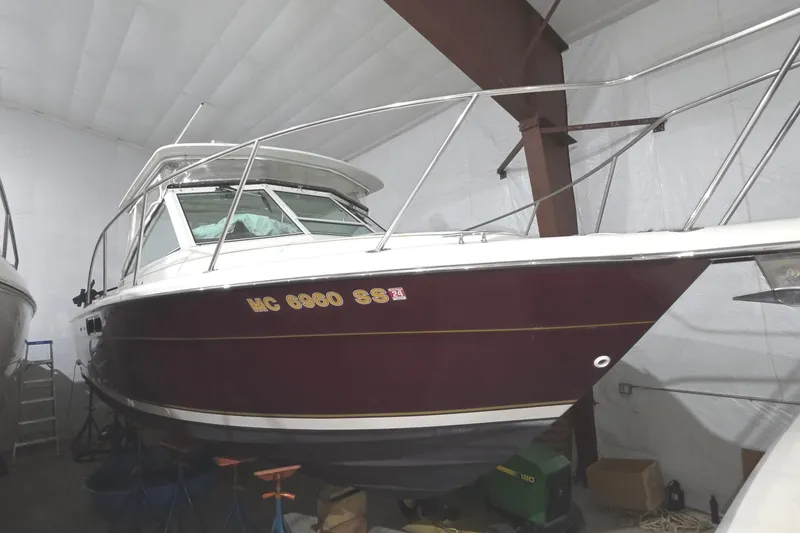The Image of 2005 Tiara 290 Coronet boat in storage, maroon hull, indoor facility. - 0