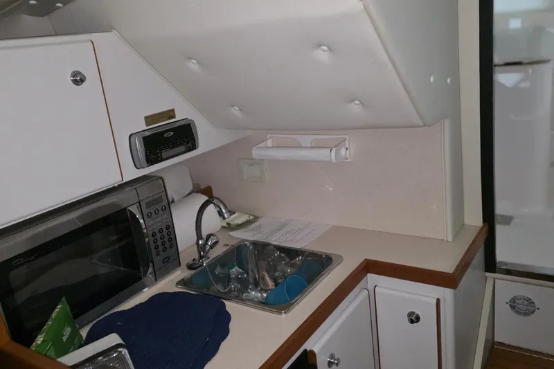 Slide: The Image of 2005 Tiara 290 Coronet boat kitchen with sink, microwave, and storage cabinets. - 18