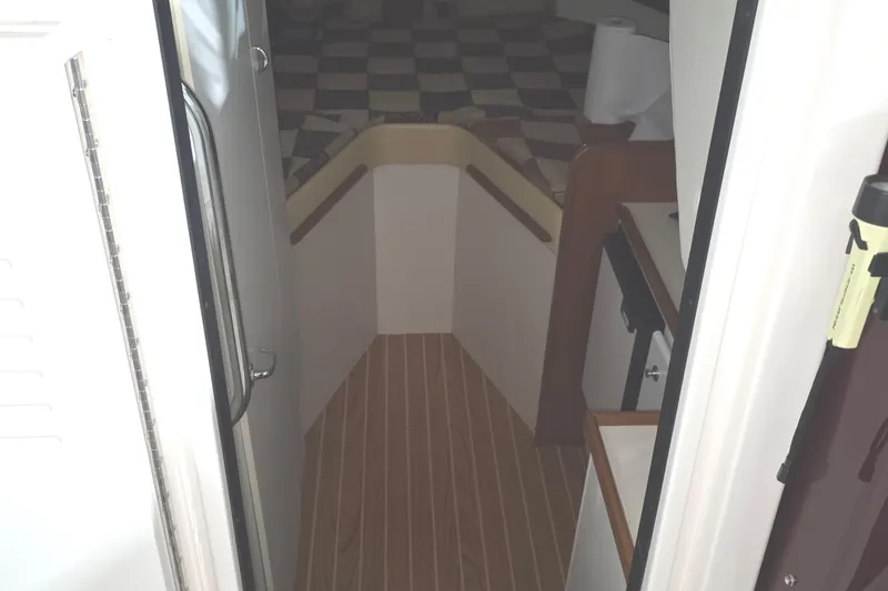 Slide: The Image of Interior view of 2005 Tiara 290 Coronet boat, featuring wooden flooring and compact cabin space. - 20