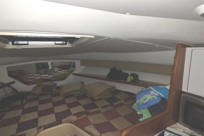 Slide: The Image of Interior cabin of a 2005 Tiara 290 Coronet boat with checkered bedding and storage. - 21