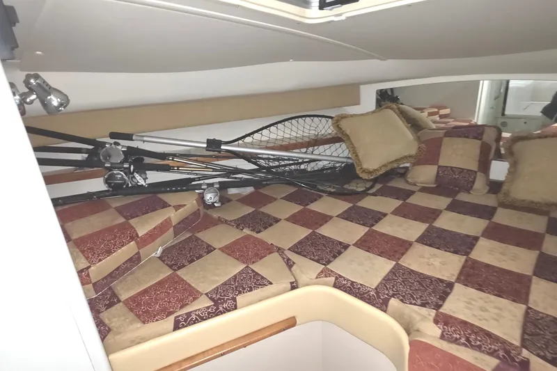 Slide: The Image of Interior of 2005 Tiara 290 Coronet boat with fishing gear and checkered bedding. - 22