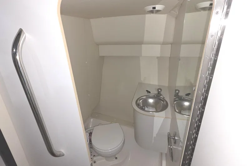Slide: The Image of Compact bathroom in a 2005 Tiara 290 Coronet boat, featuring a toilet and sink. - 24