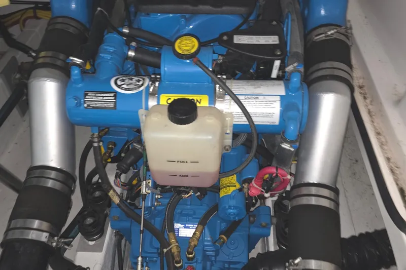 Slide: The Image of Engine compartment of a 2005 Tiara 290 Coronet boat, featuring blue components and hoses. - 31