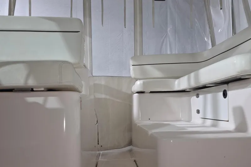 Slide: The Image of Interior seating of a 2005 Tiara 290 Coronet boat, featuring white cushioned benches. - 9