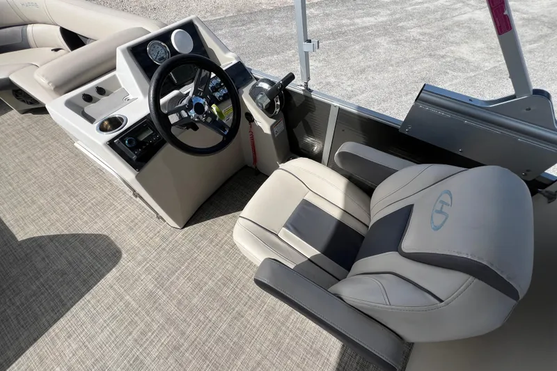 Slide: The Image of 2023 Harris Cruiser 230 boat interior with steering wheel and captain's chair. - 12
