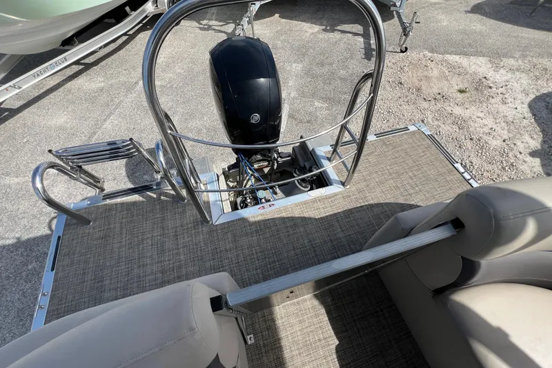 Slide: The Image of 2023 Harris Cruiser 230 boat deck with motor and seating area. - 13