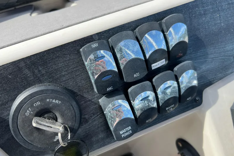 Slide: The Image of Control panel of 2023 Harris Cruiser 230 boat with ignition key and switches. - 16