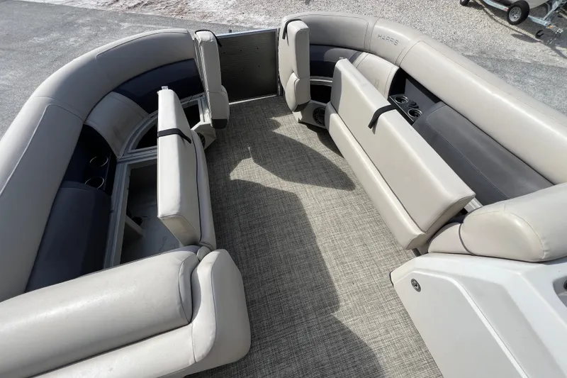 Slide: The Image of 2023 Harris Cruiser 230 boat interior with plush seating and cup holders. - 18