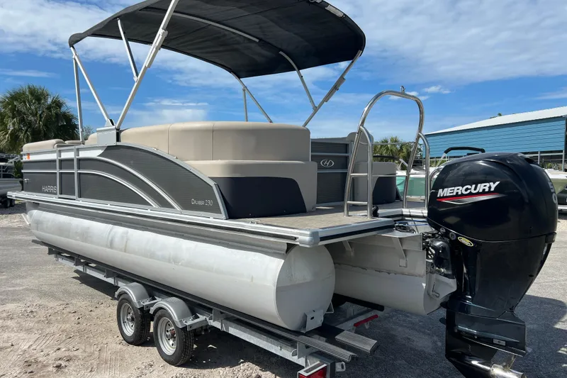 Slide: The Image of 2023 Harris Cruiser 230 pontoon boat with Mercury engine on trailer. - 6