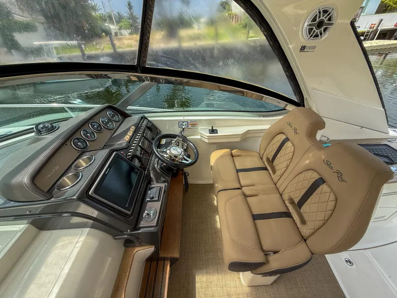 Slide: The Image of 2016 Sea Ray 350 Sundancer helm with dual seats, steering wheel, and control panel. - 11