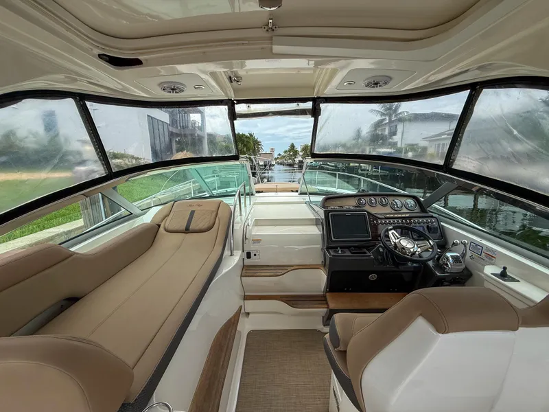 Slide: The Image of 2016 Sea Ray 350 Sundancer cockpit with beige seating and modern control panel. - 16