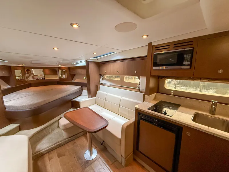Slide: The Image of Interior of 2016 Sea Ray 350 Sundancer yacht with kitchen, seating, and bed. - 18