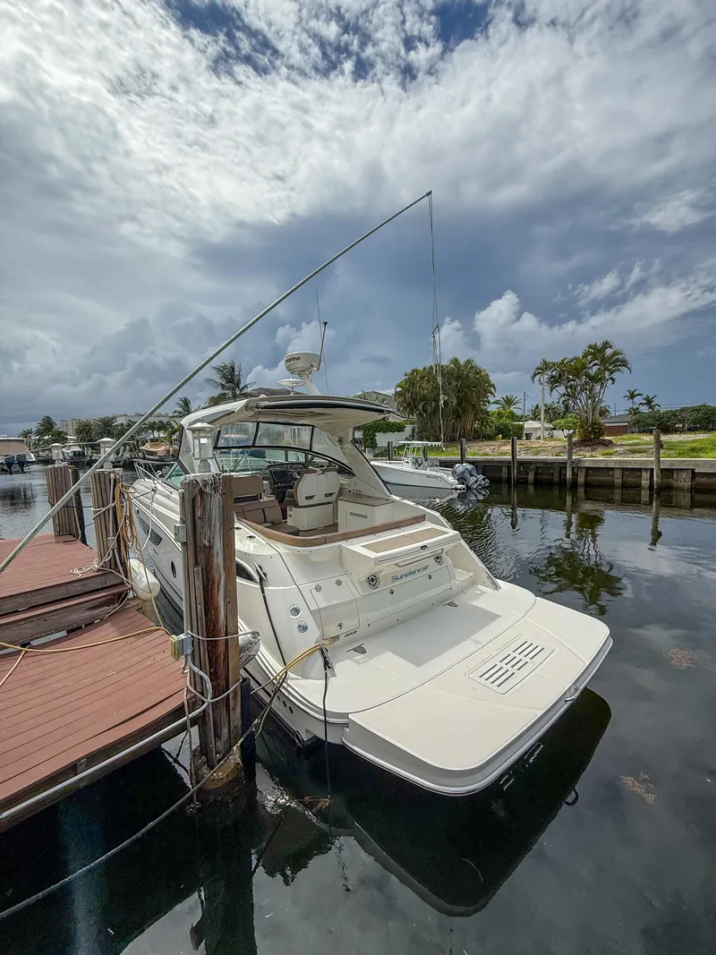 Slide: The Image of 2016 Sea Ray 350 Sundancer docked at a marina under a cloudy sky. - 2
