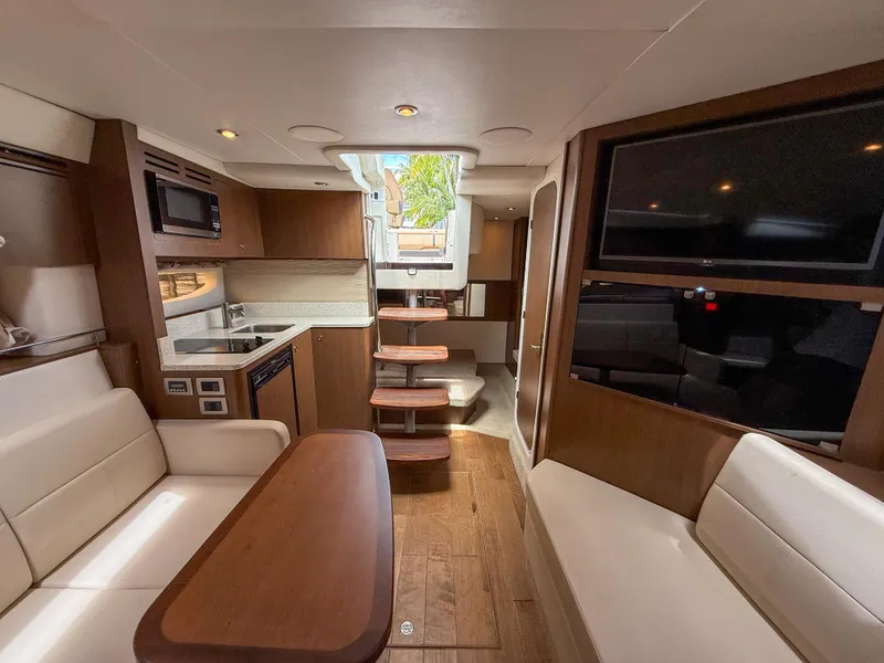 Slide: The Image of Interior of 2016 Sea Ray 350 Sundancer yacht with modern kitchen and seating area. - 23