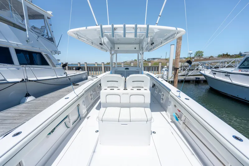 Slide: The Image of 2013 Jupiter 34 FS boat docked, showcasing spacious deck and seating area. - 10