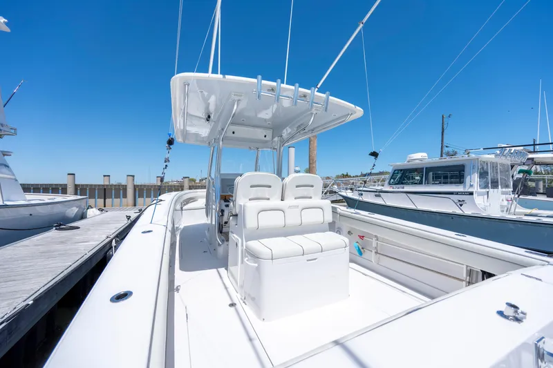 Slide: The Image of 2013 Jupiter 34 FS boat docked, featuring sleek white design and spacious seating. - 11