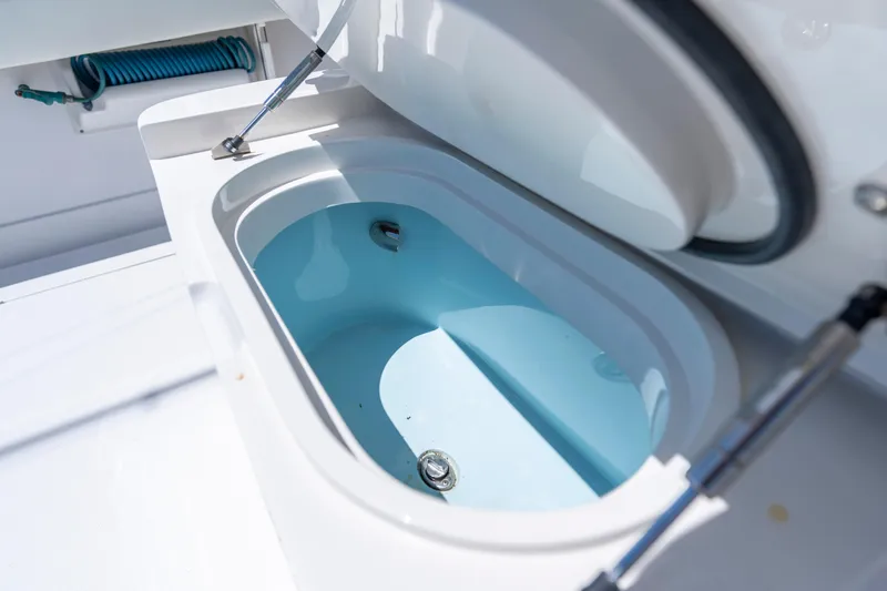 Slide: The Image of Open storage compartment on 2013 Jupiter 34 FS boat, featuring hydraulic lift and blue interior. - 13