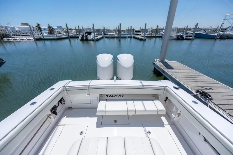 Slide: The Image of 2013 Jupiter 34 FS boat docked at marina, showcasing spacious deck and twin engines. - 15