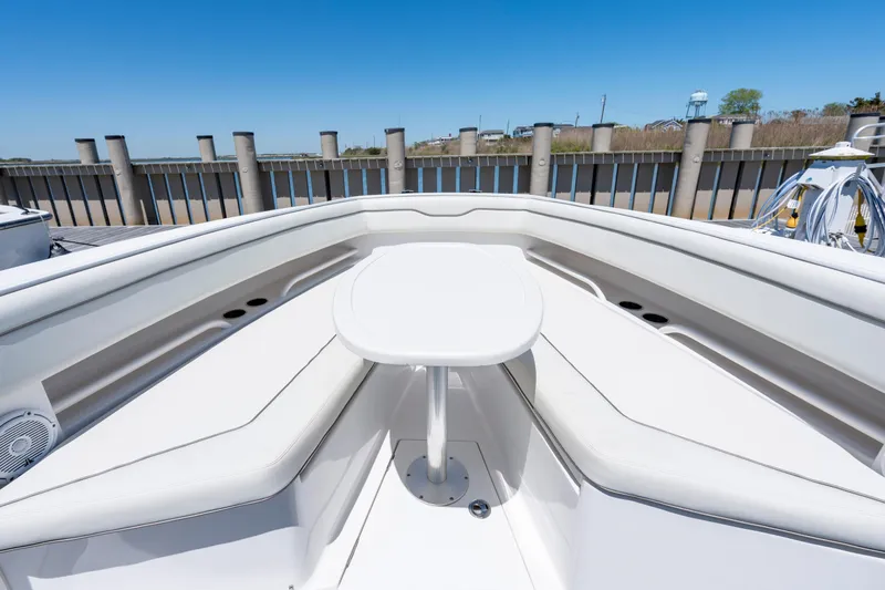 Slide: The Image of 2013 Jupiter 34 FS boat bow with seating and table, docked under clear blue sky. - 18