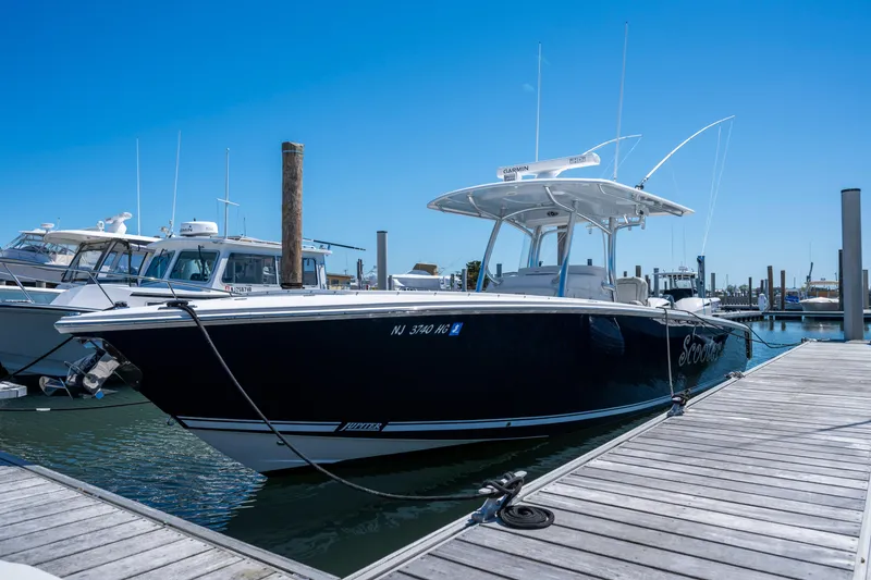 Slide: The Image of 2013 Jupiter 34 FS boat docked at marina under clear blue sky. - 2