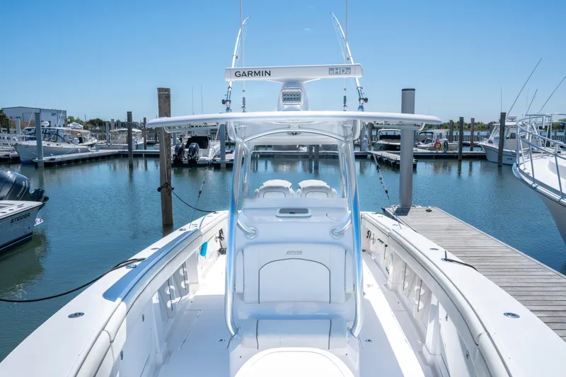 Slide: The Image of 2013 Jupiter 34 FS boat docked at marina, featuring Garmin equipment. - 22