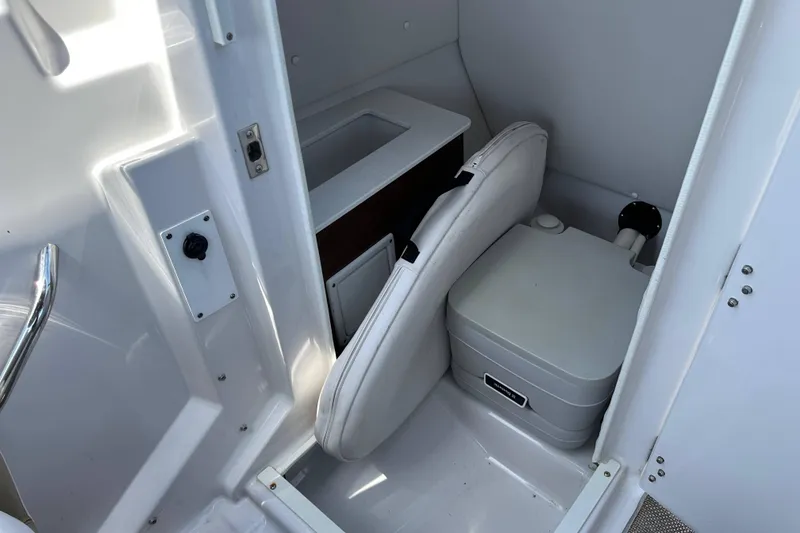 Slide: The Image of Interior of 2016 Scarab 255 H.O. Platinum boat featuring compact marine toilet. - 22