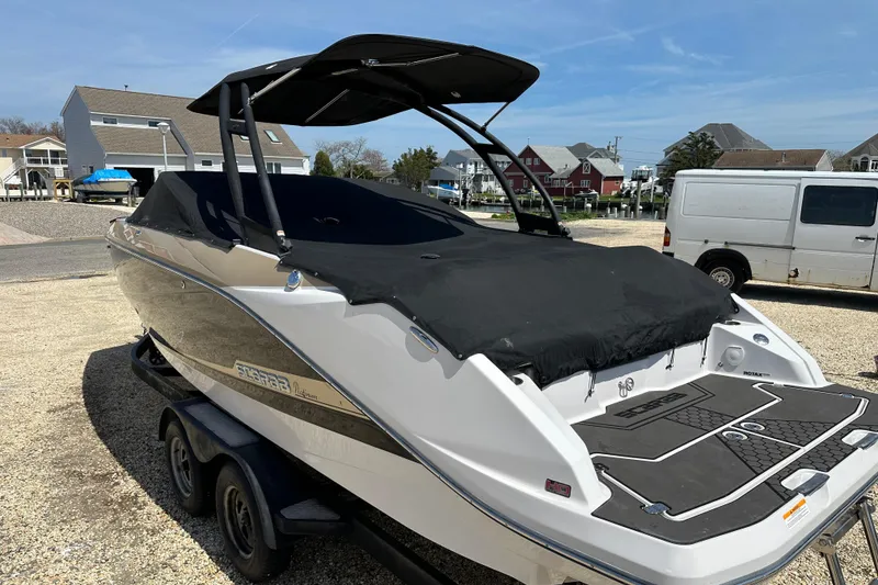Slide: The Image of 2016 Scarab 255 H.O. Platinum boat on trailer, covered and parked in residential area. - 27