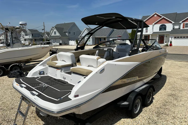 Slide: The Image of 2016 Scarab 255 H.O. Platinum boat on trailer, parked in residential area. - 3