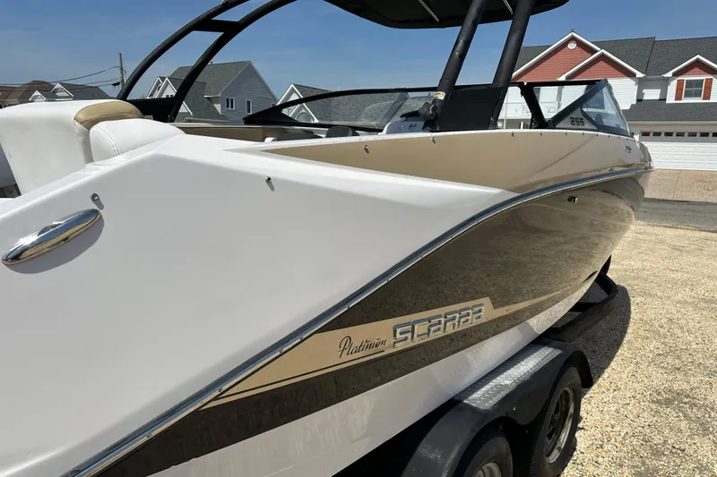 Slide: The Image of 2016 Scarab 255 H.O. Platinum boat on trailer, parked in residential area. - 7