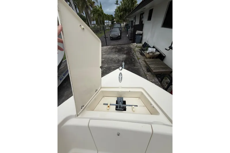 Slide: The Image of 2013 Scout 210 XSF boat with open storage compartment, outdoor setting. - 11