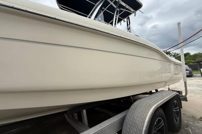 Slide: The Image of 2013 Scout 210 XSF boat on trailer, side view under cloudy sky. - 17