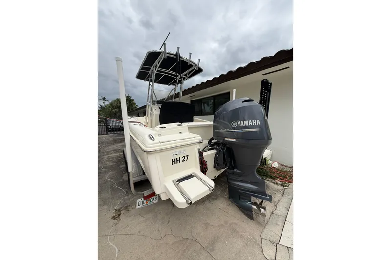Slide: The Image of 2013 Scout 210 XSF boat with Yamaha outboard motor, parked outdoors. - 4