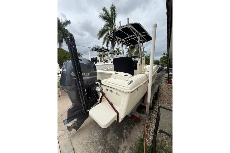 Slide: The Image of 2013 Scout 210 XSF boat with Yamaha engine, parked outdoors under cloudy skies. - 5
