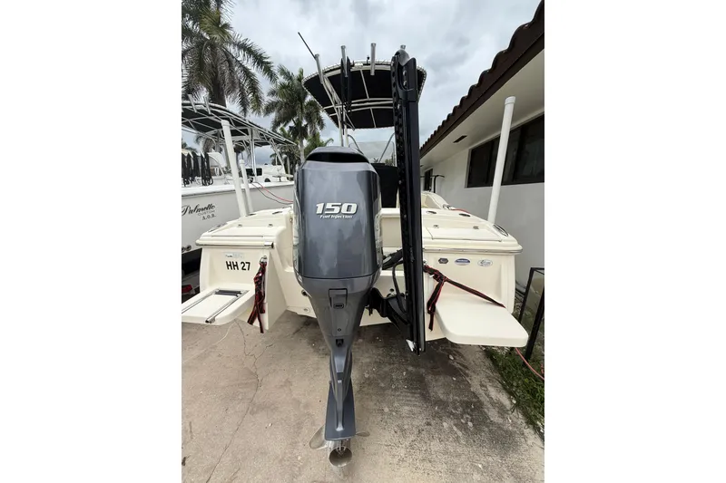 Slide: The Image of 2013 Scout 210 XSF boat with 150 horsepower engine, parked outdoors. - 6