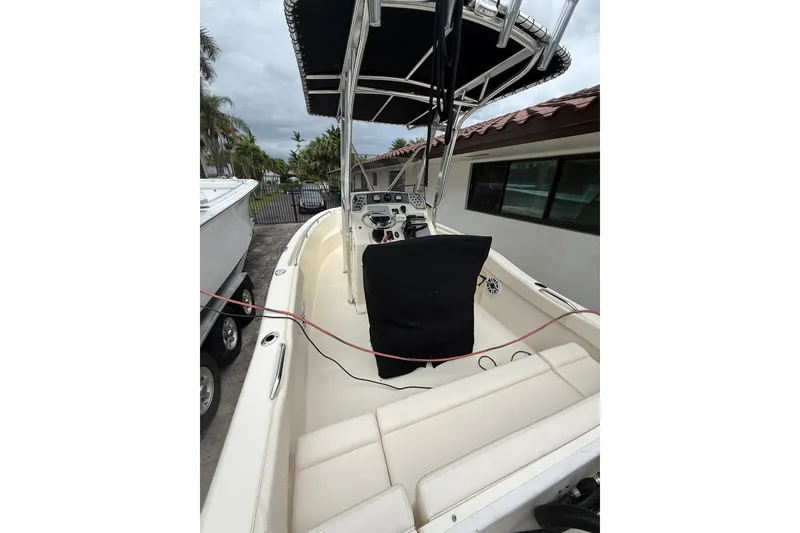 Slide: The Image of 2013 Scout 210 XSF boat interior with seating and control panel, docked outdoors. - 7