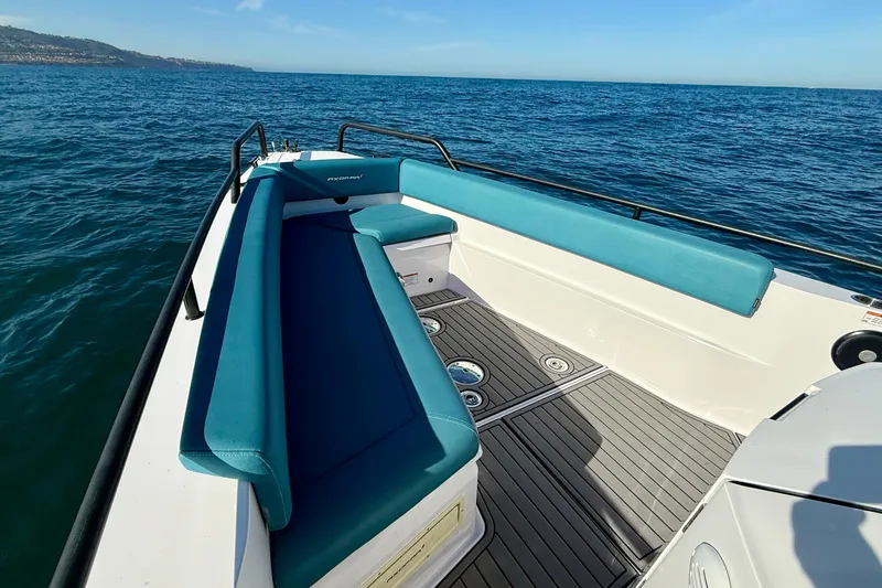 Slide: The Image of 2021 Axopar Brabus 28 Cabin boat with teal seating on open water. - 12