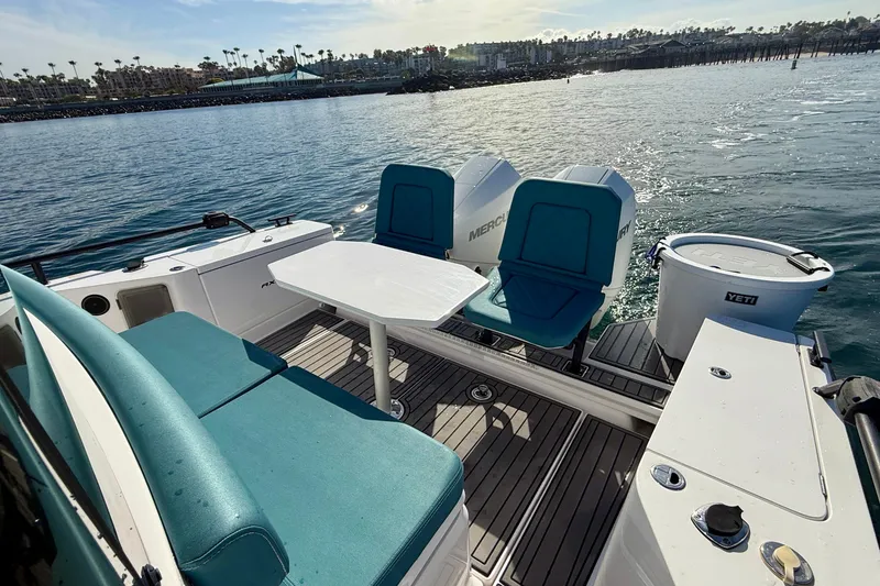 Slide: The Image of 2021 Axopar Brabus 28 Cabin boat interior with seating and table on the water. - 21