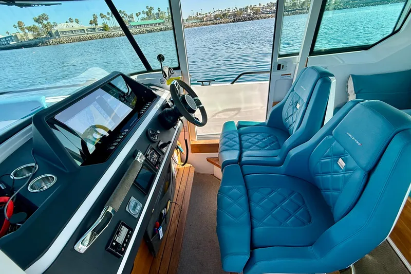 Slide: The Image of 2021 Axopar Brabus 28 Cabin interior with blue seats and modern dashboard. - 41