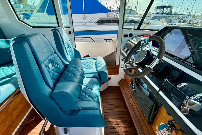 Slide: The Image of Interior of 2021 Axopar Brabus 28 Cabin with blue seats and modern dashboard. - 42