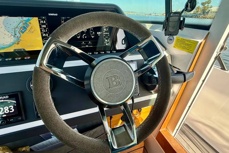 Slide: The Image of Steering wheel of 2021 Axopar Brabus 28 Cabin with navigation display. - 45